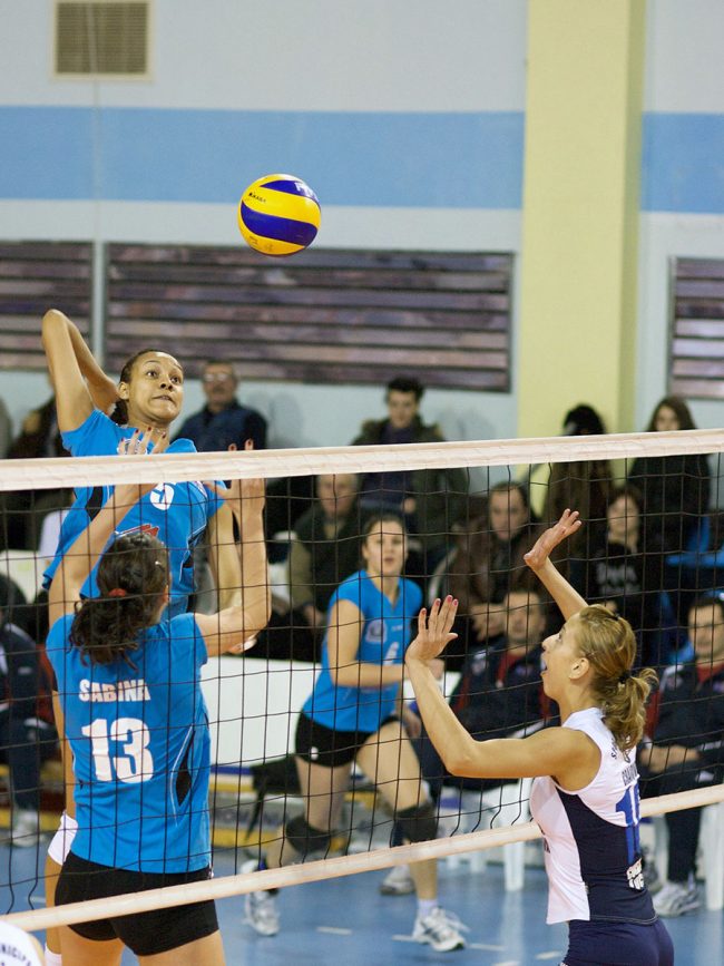 Voleyball players are fighting over the ball in a game played in Galați, Romania on February 20th, 2010.